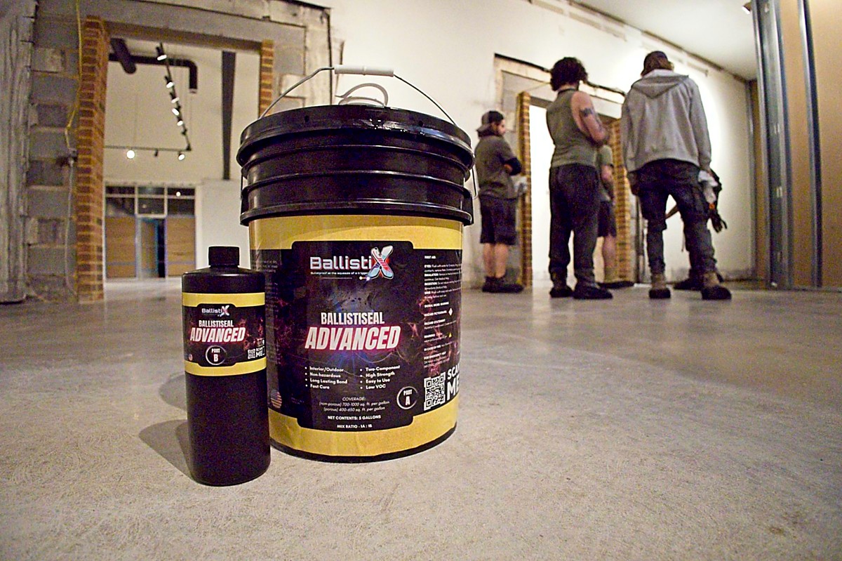 Epoxy flooring contractor inspecting a concrete floor with a homeowner