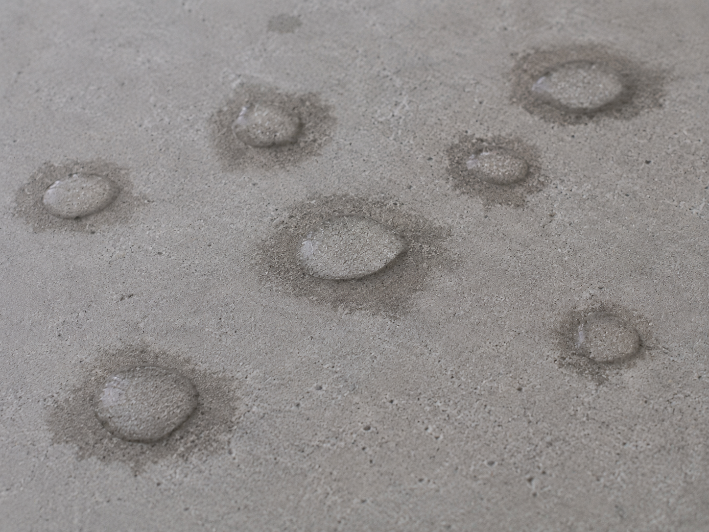 Water slowly absorbing into concrete