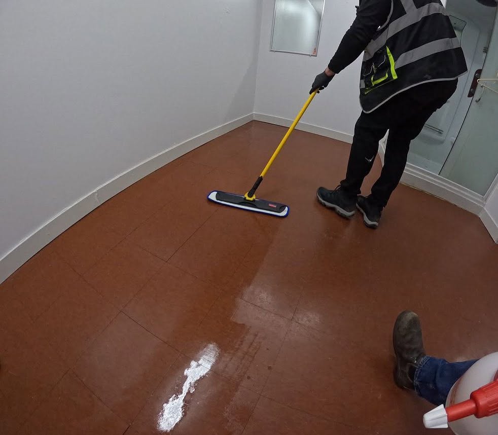 Applying floor sealer with mop