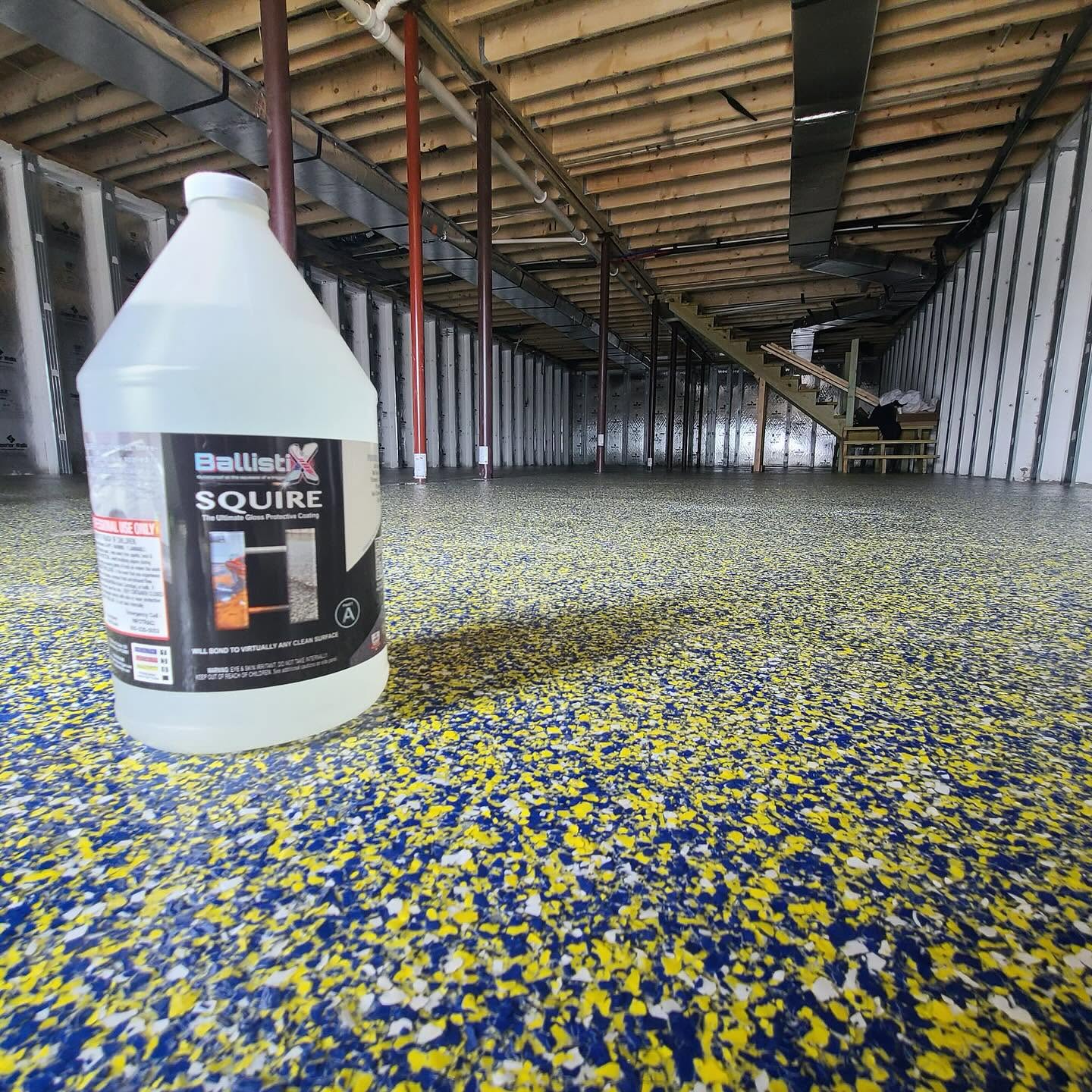 Contractor applying BallistiX Squire over flake floor